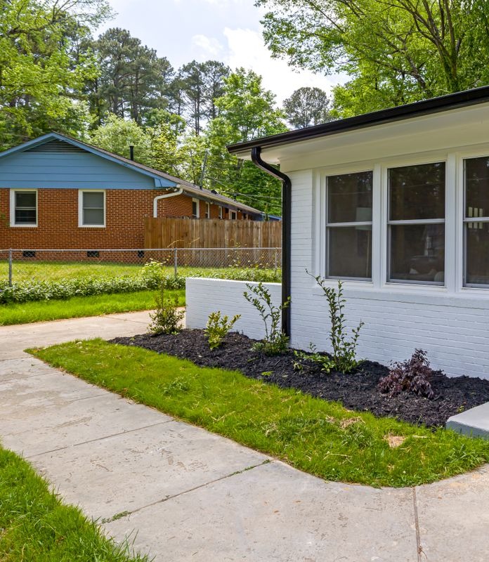 Illustrative front-porch exterior in a leafy residential setting; not a photo of Pinehurst Apartments