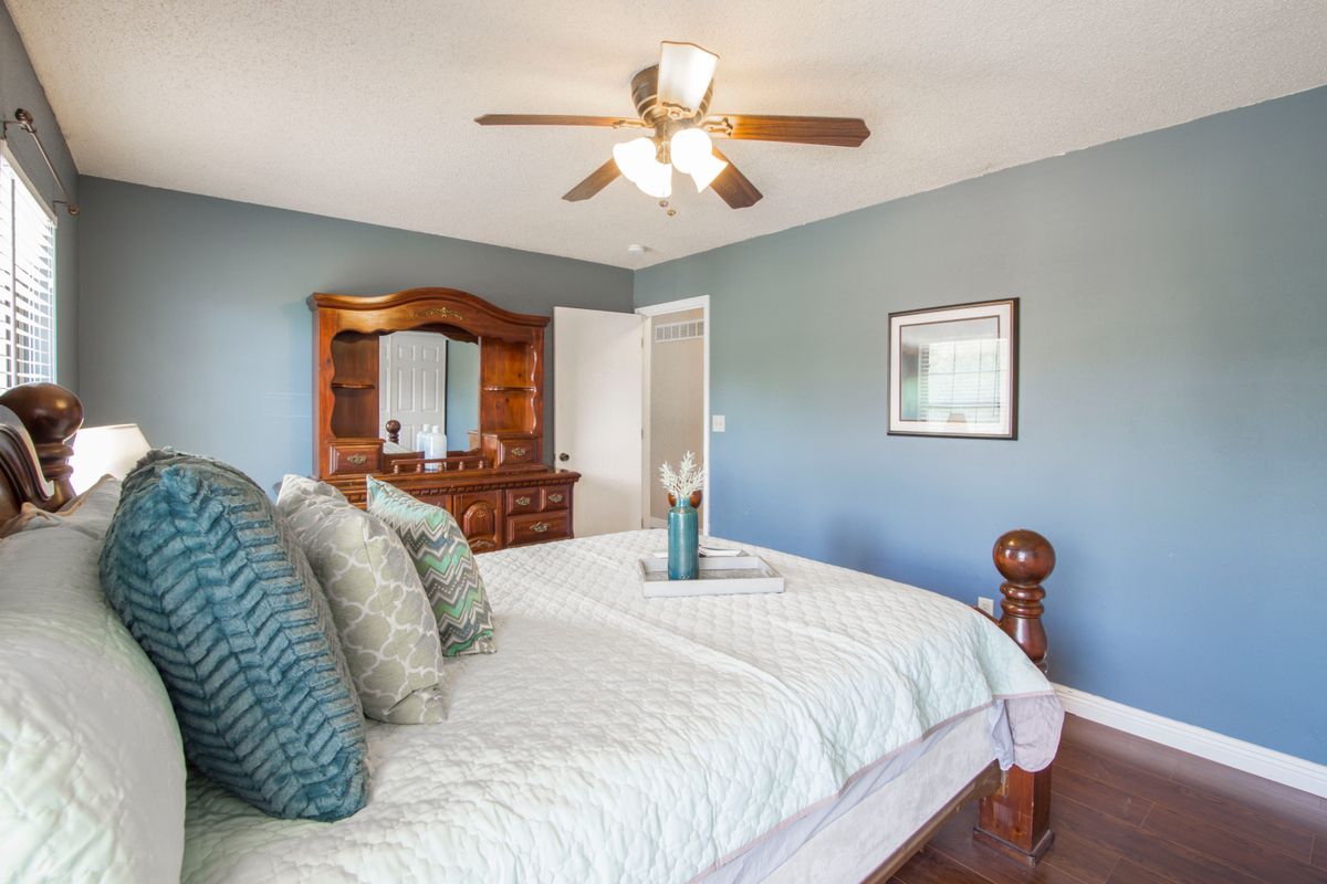 Illustrative furnished bedroom with blue walls and natural light; not a photo of Arbor Village Apartments